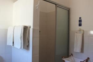 a shower with a glass door in a bathroom at Beach Haven Cottage in Britannia Bay +23 photos