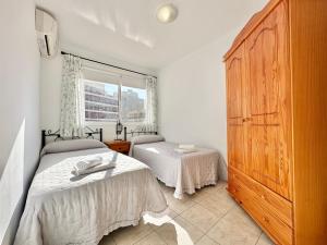 1 dormitorio con 2 camas y un gran armario de madera en Santiago Sun, en Puerto de Santiago