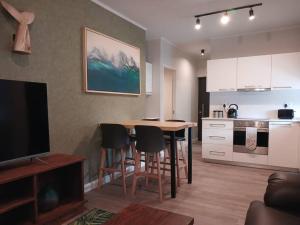 a living room with a table and chairs and a kitchen at 101 Mossel Cove in Mossel Bay