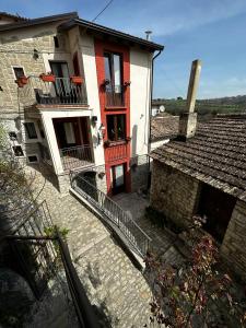 an old house with red doors and balconies on a street at Dimora Forgione B&B - Pietrelcina in Pietrelcina
