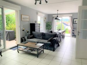a living room with a couch and a table at Trés belle villa 4 étoiles - 3 chambres - Terrasse et jardin in Cambo-les-Bains