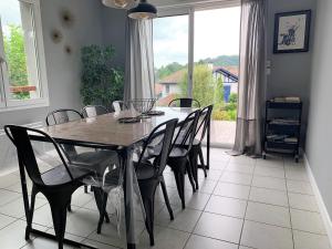 a dining room with a table and chairs and a window at Trés belle villa 4 étoiles - 3 chambres - Terrasse et jardin in Cambo-les-Bains
