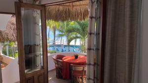 a room with a red table and chairs and a balcony at Bungalows Lydia San Pancho in San Francisco