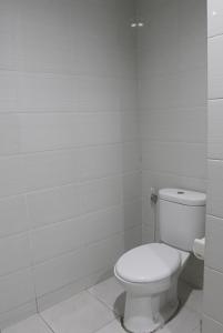 a white bathroom with a toilet in it at Ronta Bungalows in Legian