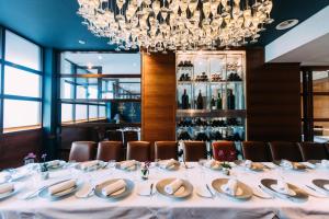 a long table in a restaurant with a chandelier at The Club Hotel & Spa Jersey in Saint Helier Jersey +40 photos