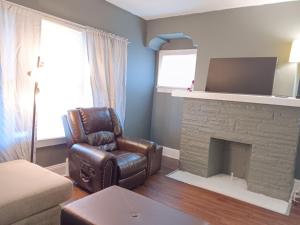 a living room with a leather chair and a fireplace at Experience a home near Cleveland Clinic & parks in Cleveland