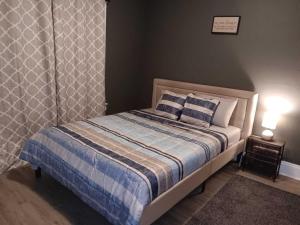 a bedroom with a bed with a blue and white blanket at Experience a home near Cleveland Clinic & parks in Cleveland