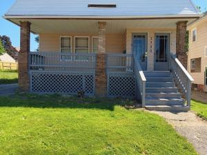 a house with a blue front porch and stairs at Experience a home near Cleveland Clinic & parks in Cleveland