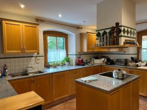 a kitchen with wooden cabinets and granite counter tops at Zwieslerwaldhaus4 in Lindberg +19 photos