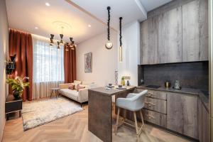 a kitchen and living room with a table and a couch at Poppy Apartments in Vilnius