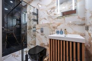 a bathroom with a sink and a shower at Poppy Apartments in Vilnius