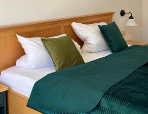 a bed with green and white pillows on it at Zwieslerwaldhaus4 in Lindberg