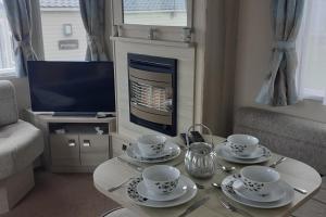 a living room with a coffee table with a fireplace at PerranporthCaravan 2bedroom Tv GasFire in Perranporth
