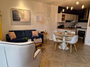 a living room and kitchen with a table and chairs at Gîte le talus in Amanlis