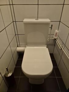 des toilettes blanches dans une salle de bains carrelée dans l'établissement Mi casa su casa, à Schiedam