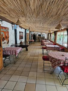 a dining room with tables and chairs in a restaurant at Hotel Club Safari in Mbour