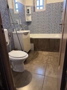 a bathroom with a toilet and a sink and a tub at Apartament BLD N Titulescu in Craiova