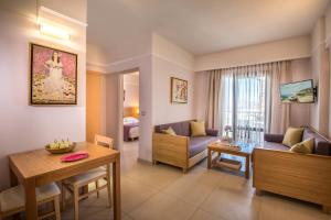 a living room with a couch and a table at Porto Platanias Village Resort in Plataniás
