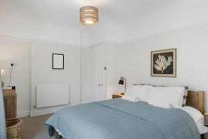 een slaapkamer met een bed met een blauwe deken bij Spacious House & Garden in Ilfracombe in Ilfracombe