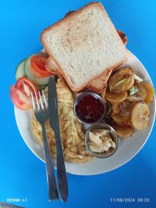 a plate of breakfast food with toast and fruit at Unique point home stay in Nagarkot