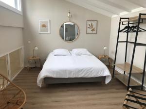 a bedroom with a white bed and a mirror at Duplex LOUIS - Mon Gîte Facile in Horbourg