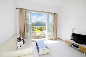 a living room with a white couch and a large window at Walking Sky Pension in Gapyeong