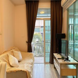 a bedroom with a bed and a desk with a television at Stylish room Near Central Fest in Chiang Mai