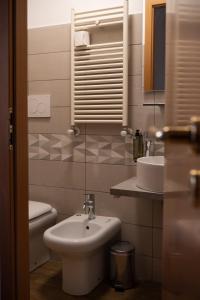 Un baño con lavabo, inodoro y espejo. en Lux of the Vatican, en Roma