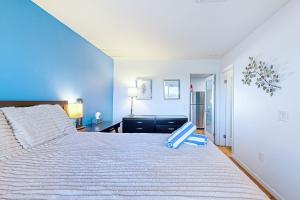 a bedroom with a large bed with a blue wall at Biarrtx D20 in Palm Springs +24 photos