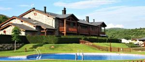 a house on a hill with a pool in front of it at Bonita planta baja con vistas panorámicas y piscina in Enveitg