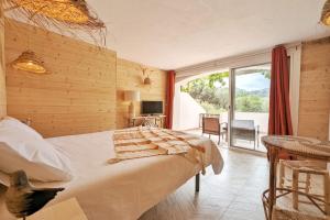 a bedroom with a bed and a large window at L'Évasion Naturelle N1 des Villages des Français in Argelès-sur-Mer