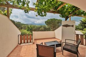 a patio with a table and chairs on a balcony at L'Évasion Naturelle N1 des Villages des Français in Argelès-sur-Mer