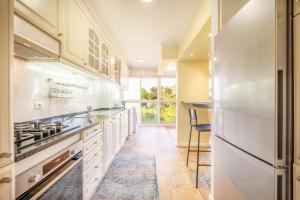 Una cocina con gabinetes blancos y un refrigerador. en GuestReady - Quiet Retreat in Cascais, en Cascais