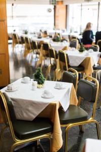 una fila de mesas con manteles blancos. en Grand Hotel, en Larisa