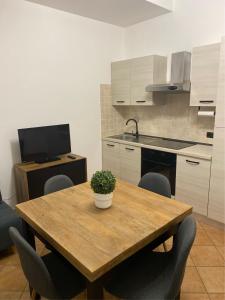 a kitchen with a wooden table with chairs and a television at Little House in Fiumicino