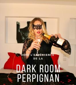 a woman is pouring a bottle of wine at Dark Room Perpignan aux 50 nuances Jacuzzi Privé in Villeneuve-de-la-Raho