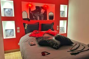 a bedroom with red walls and a bed with skis on it at Dark Room Perpignan aux 50 nuances Jacuzzi Privé in Villeneuve-de-la-Raho