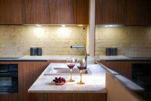 two glasses of wine sitting on a kitchen sink at ARVED Apartments in Lübeck +54 photos