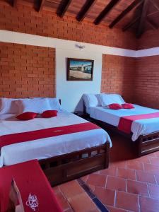 una camera da letto con due letti e un muro di mattoni di Eco - Hotel San Miguel Barichara Campestre - Arte y café a Barichara Altre 39 foto