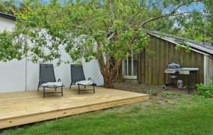 two chairs sitting on a wooden deck next to a tree at Awesome Home In Humble With Wifi in Humble