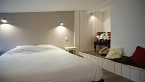 a bedroom with a white bed and a chair at Little Suite - Nathan in Lille