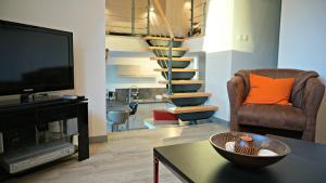 a living room with a television and a staircase at Little Suite - Nathan in Lille