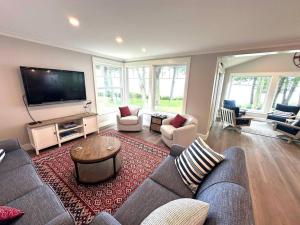 ein Wohnzimmer mit Couch und Fernseher in der Unterkunft The Blue Bungalow, Seneca Lake in Penn Yan