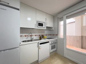 Una cocina con gabinetes blancos y un microondas. en TAYP San Marcos 106, en Talayuela 21 fotos más