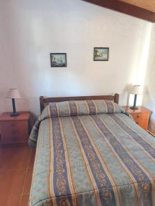 una camera da letto con un letto con due comodini e due lampade di Casa para 4 en San Luis - Increible vista al mar!! a San Luis