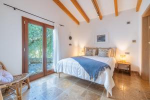 ein Schlafzimmer mit einem Bett und einem großen Fenster in der Unterkunft Cal Rei Gran in Pollença + 31 Fotos