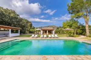 ein Swimmingpool mit Stühlen und einem Pavillon in der Unterkunft Cal Rei Gran in Pollença