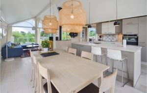 a kitchen and dining room with a wooden table and chairs at Holiday Home Ebeltoft With A Fireplace 9 in Ebeltoft