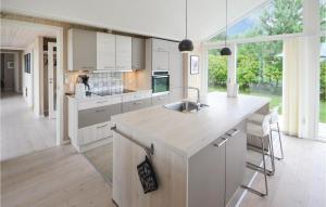 a kitchen with white cabinets and a large window at Holiday Home Ebeltoft With A Fireplace 9 in Ebeltoft