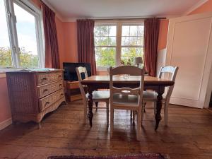 a dining room with a table and chairs and a dresser at Ullapool Lawyur's patch in Ullapool +7 photos
